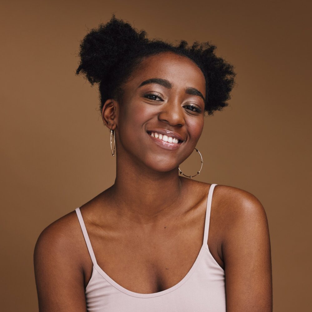 Black woman, smile and student portrait of a gen z person with makeup and jewelry in a studio. Isol